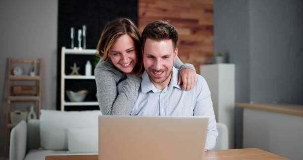istock Happy Couple Looking At Laptop 1448682085