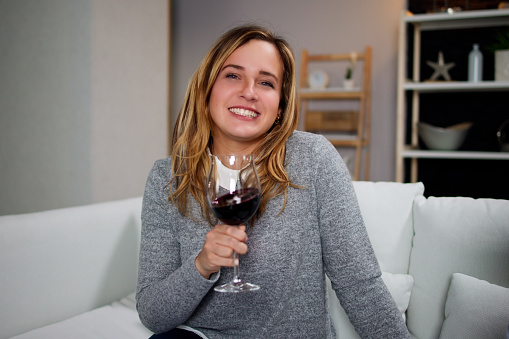 Woman Drinking Red Wine In Video Conference At Home