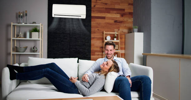 Happy Family Couple Using Air Conditioner Happy Family Couple Using Air Conditioner. Apartment AC air conditioner family stock pictures, royalty-free photos & images
