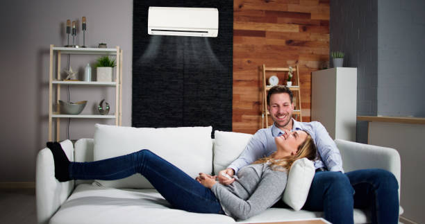 istock Happy Family Couple Using Air Conditioner 1448682622