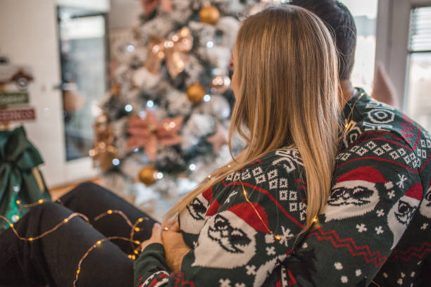 istock A loving couple enjoys relaxing by the Christmas tree 1448682776
