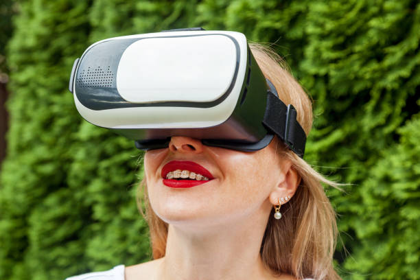 istock Girl with virtual reality glasses in the park 1448683857
