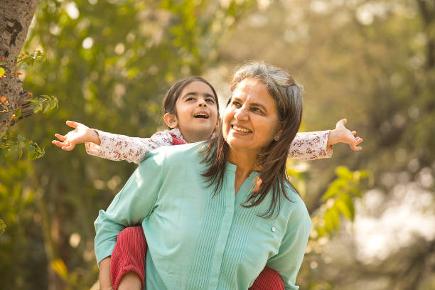 istock Senior woman piggybacking granddaughter in park during weekend 1448685204