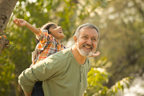 istock Senior man piggybacking grandson in park during weekend 1448685354