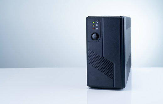 Uninterruptible power supply on white background. Backup Power UPS with battery. UPS with stabilizer for home PC. UPS inverter. Equipment for computer system at office for security. Power protection.