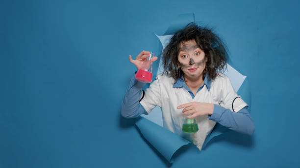 istock Foolish crazy chemist doing silly grimace and holding beakers 1448687518