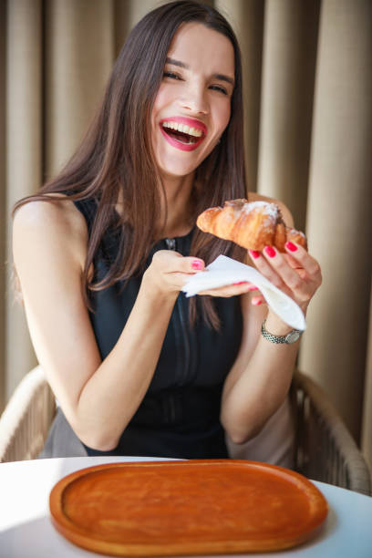 istock Beautiful woman smiling and having dessert at restaurant table 1448688025