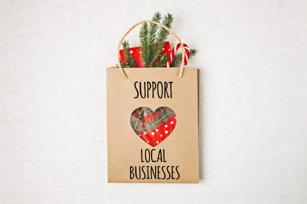 istock Support Local Business text written on paper shopping bag. Flat lay with Support Local Business quote, Christmas decoration and shopping bag, gift boxes and staff. 1448688473