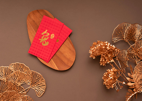 Red and gold Chinese New Year decorations over brown, viva magenta background with copy space. Happiness, wealth and luck.
