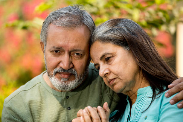 istock Thoughtful senior couple sitting together in park 1448694183