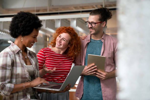 istock Diverse group of professionals meeting in office. IT programmers use computer, talk strategy 1448695320