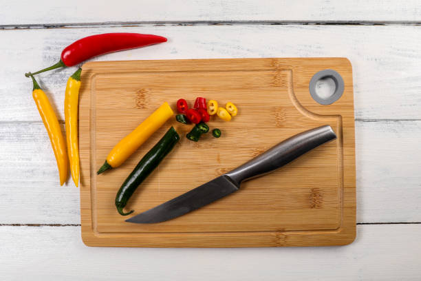 istock Red, green and yellow peppers on a bamboo cutting board 1448696883
