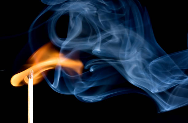 A match creating a flame with smoke Match flame and smoke lit match stock pictures, royalty-free photos & images