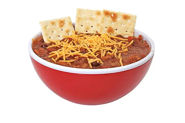 Bowl of hot chili with beans, cheese, and crackers.  Isolated on white background with clipping path.