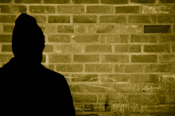 siliouhete of a young black man against a graffiti wall 