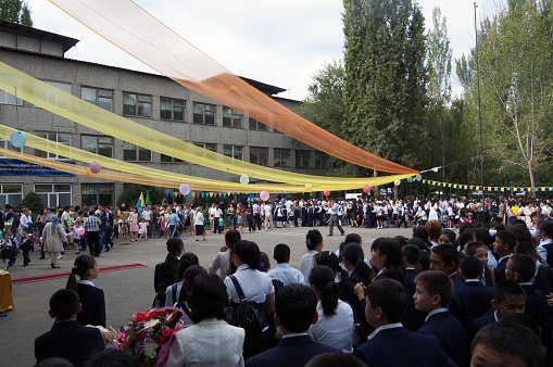 First day of school celebration before a elementary school in Almaty City (Kazakhstan). Children with flowers and their school uniforms.