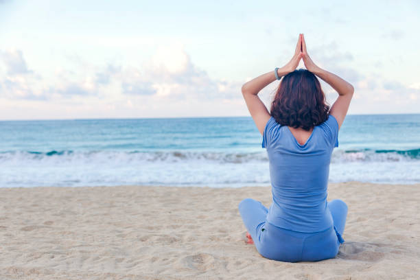 Asian women  doing yoga on the beach stock photo