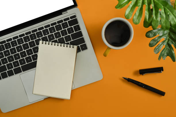 istock Laptop computer, notepad, coffee cup and houseplant on yellow background. 1448705400