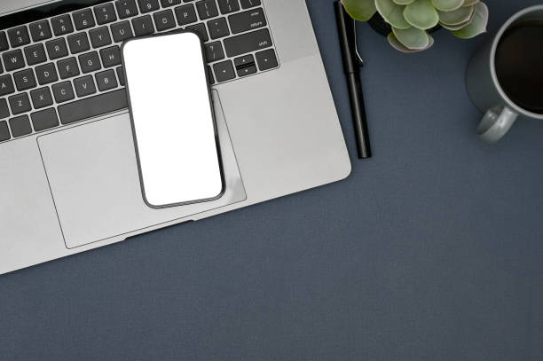 istock Modern workspace with smartphone mockup is on laptop keyboard on blue background. top view 1448705640