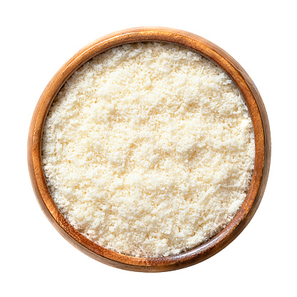 Grated Grana Padano cheese, in a wooden bowl. Italian hard cheese, similar to Parmesan, with strong savory flavor and slightly gritty texture, made from unpasteurized cow milk. Used for pasta dishes.