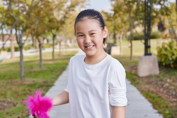 Happy girl holding shuttlecock looking at camera and smiling