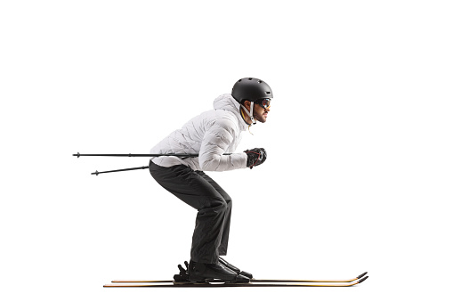 Full length profile shot of a male skier skiing isolated on white background