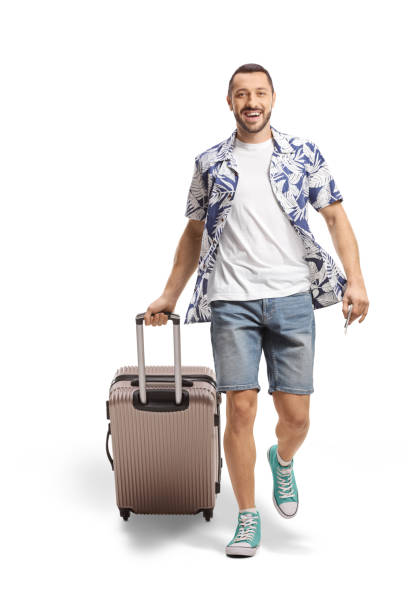 istock Full length portrait of a smiling man walking and pulling a suitcase 1448709684