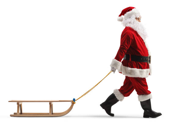 Immagine di profilo a figura intera di Babbo Natale che tira una slitta di legno isolata su sfondo bianco - foto stock