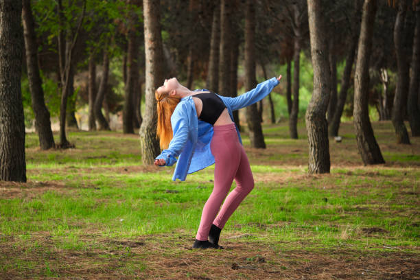 istock Redhead young woman practicing contemporary dance in a forest. 1448709859