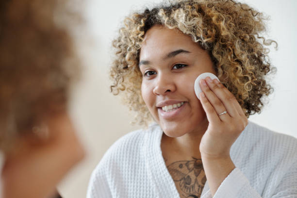istock Young smiling woman applying makeup remover with cotton pad 1448709912