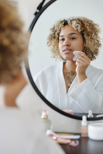 istock Young woman with quartz scraper massaging her face 1448709966