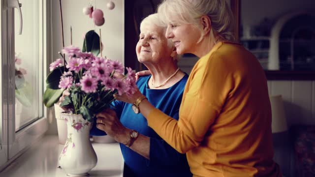 Woman spending time with her elderly mother at home