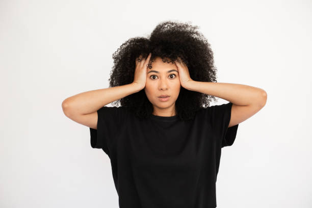 istock Astonished young woman holding hands on her head from shock 1448711849