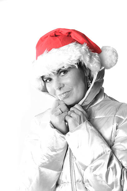 Woman with a Christmas hat that is selectively colored to enhance the red. Isolated on white with strong lighting on left side of image.