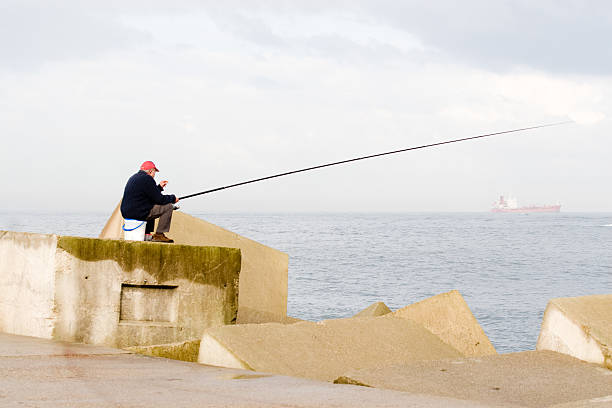 senior fishing from the concrete blocks of a levee
