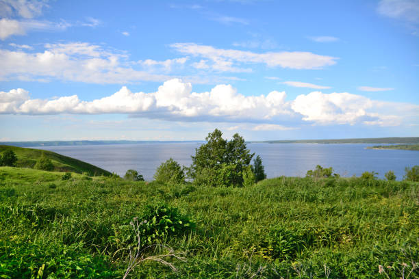 istock landscape with green hill and tree, river on horizon and white clouds on blue sky 1448720376