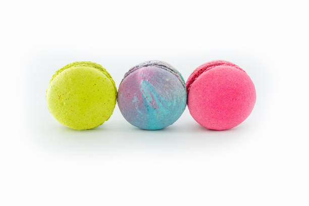istock Brightly colored stacked French macarons on white background. Tasty colorful macaroon assorted. Three sweet cakes of different colors. Pastry made from egg whites. Culinary, food and cooking concept. 1448720861