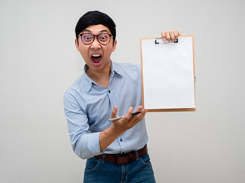 Asian businessman wear glasses blue shirt feels shocked show document board in his hand up isolated