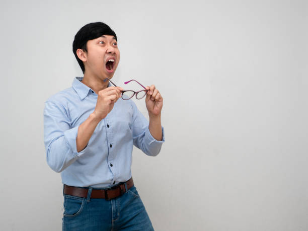 joven empresario siente conmocionado gesto de quitarse las gafas luciendo aislado - businessman 30s low key surprise fotografías e imágenes de stock