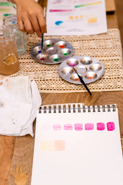 istock Watercolor workshop. Work table with brushes and water jars. 1448722574