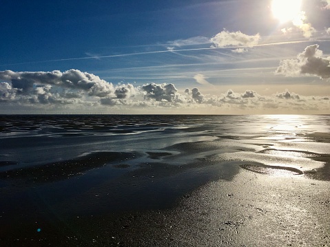 October 8th 2022. Southwick, Dumfries, Scotland, UK.  The Autumn sea and cloudscape over the beach at Southwick on the  Solway Firth, was particularly striking that afternoon, the distant wind turbines can be seen peppering the far horizon.