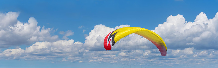 A blue sky and white clouds in the background, a close-up parachute