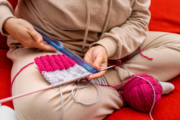 istock Young girl measuring her knitting progress with a ruler. 1448723541