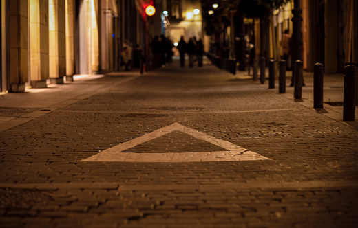 White triangle sign on street at night. Madrid, Spain
