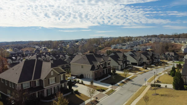 istock Aerial view upscale houses with side garage entry in new development subdivision sprawl leads to horizontal line under rare cloud formation suburbs Atlanta, Georgia, USA 1448733031