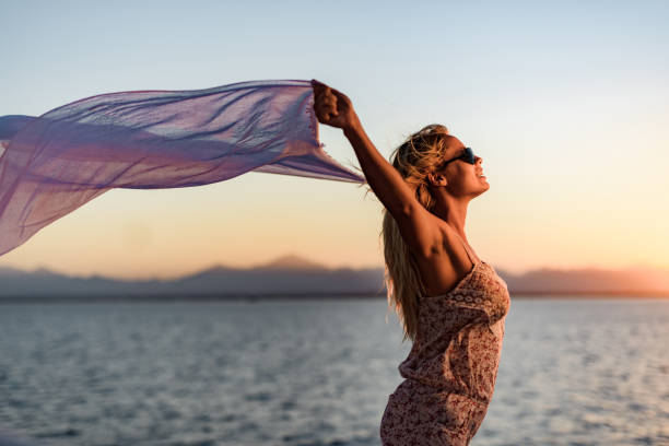 istock Happy woman with shawl on a windy day at sunset. 1448733074