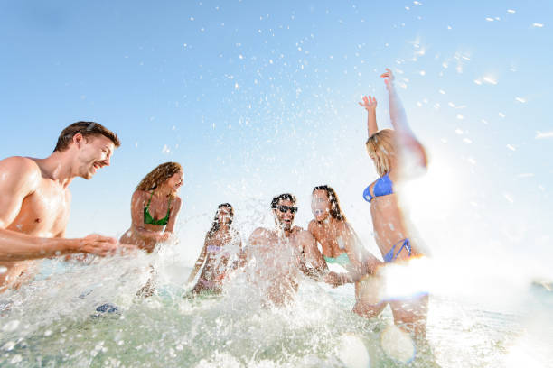 istock Playful people splashing each other in the sea. 1448734236