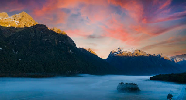 a vista da montanha da cena do outono e nebulosa pela manhã com a cena do céu do nascer do sol no parque nacional fiordland - sunrise new zealand mountain range mountain - fotografias e filmes do acervo