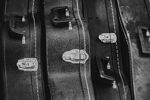 A closeup grayscale shot of vintage banjo and guitar cases.