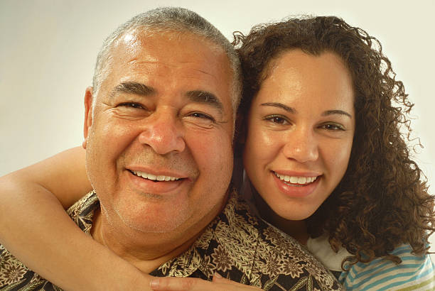 Daughter with her arm around her father both smiling stock photo